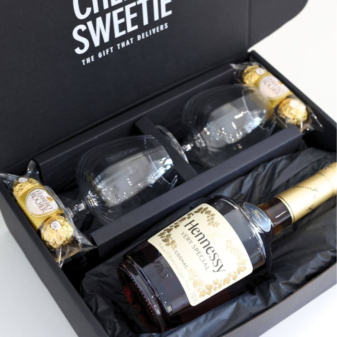Hennessy cognac bottle with two glasses and chocolate in a black gift Hamper box
