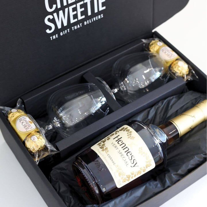 Hennessy cognac bottle with two glasses and chocolate in a black gift Hamper box