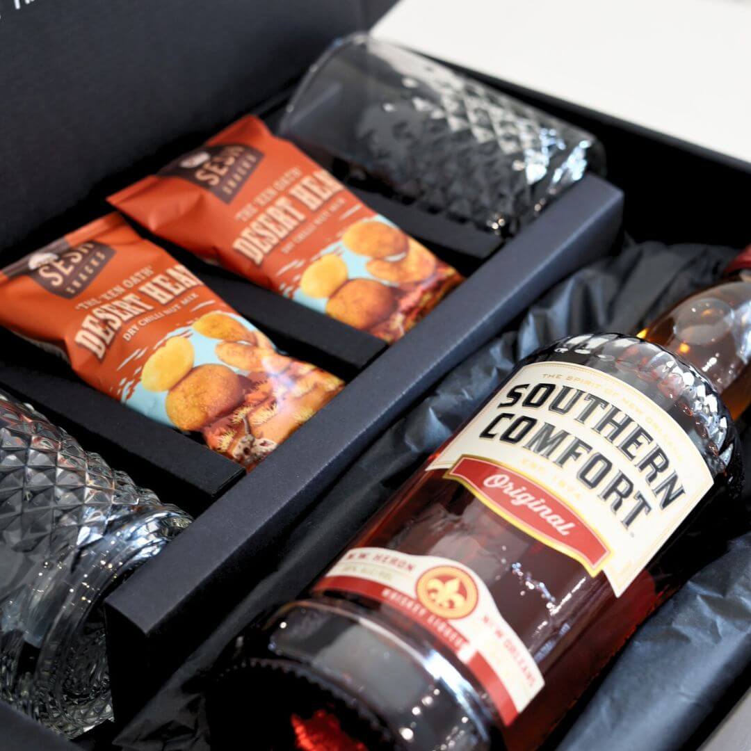 Gift set with Southern Comfort bottle, snacks, and glasses.